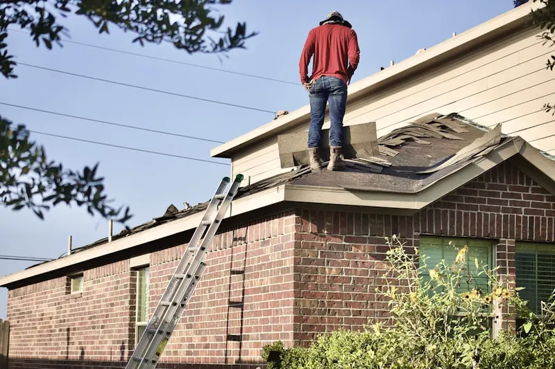 Professional roofer working on a residential roof in Ada